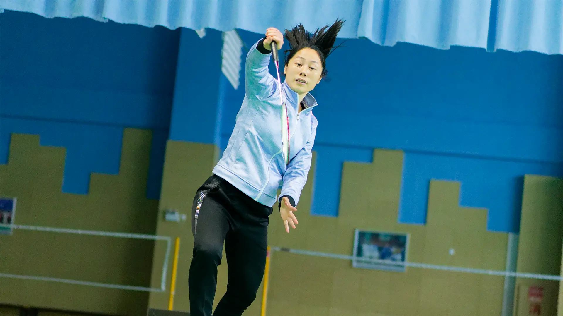 Head Coach Yunyi Zhu hitting an overhead shot