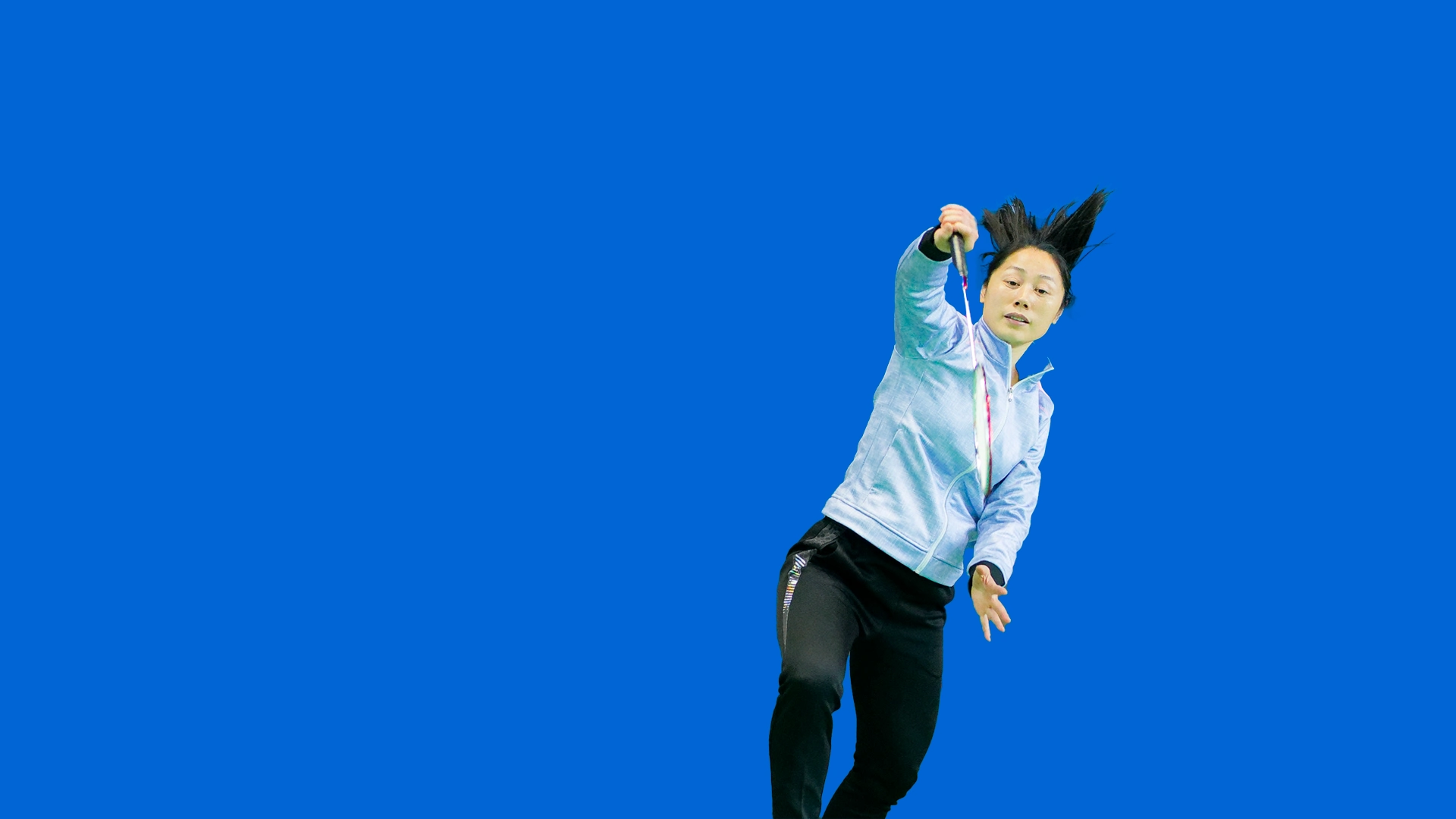 PureKing coach demonstrating an overhead badminton shot